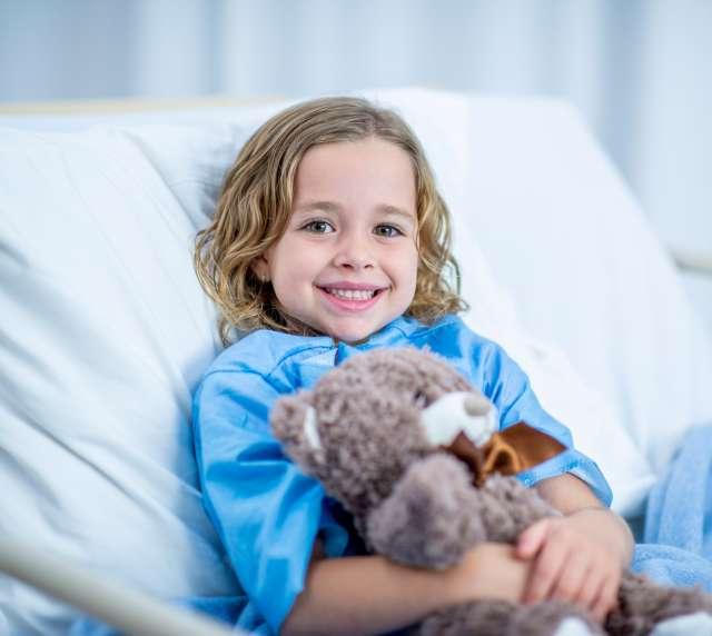 Child in hospital bed smiling
